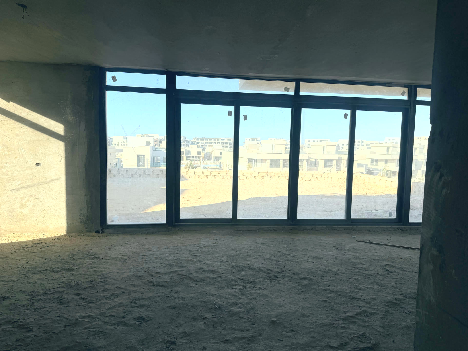 صالة الدور الأرضي بنوافذ زجاجية ممتدة بعرض الجدار